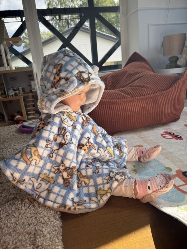 Kõrvakestega, kiikhobudega ja kaelkirjakutega autosõidu poncho lapsele vanuses 0-1 aastat